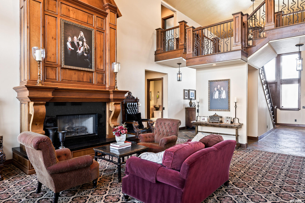 Living room featuring a large fireplace and a high ceiling