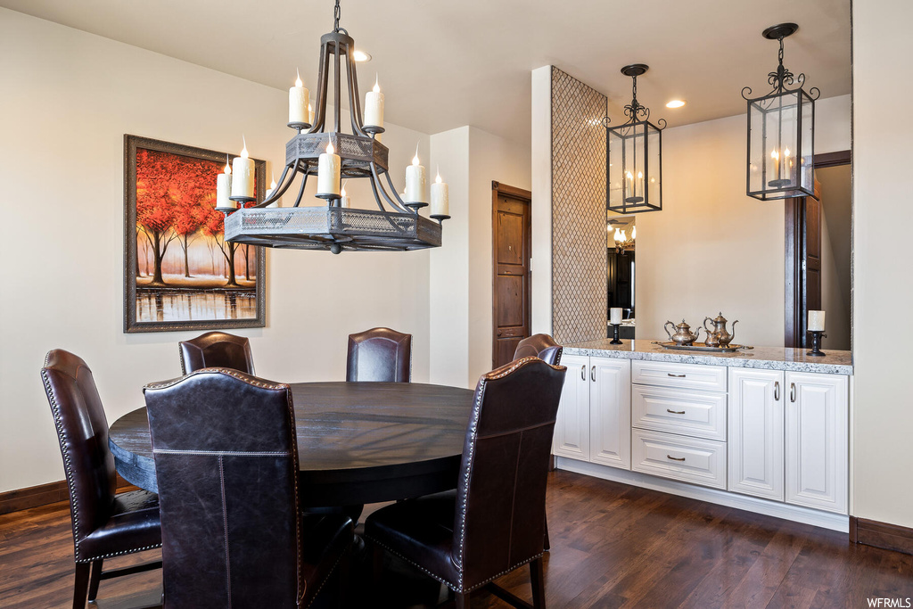 Dining area with a chandelier and dark hardwood / wood-style floors