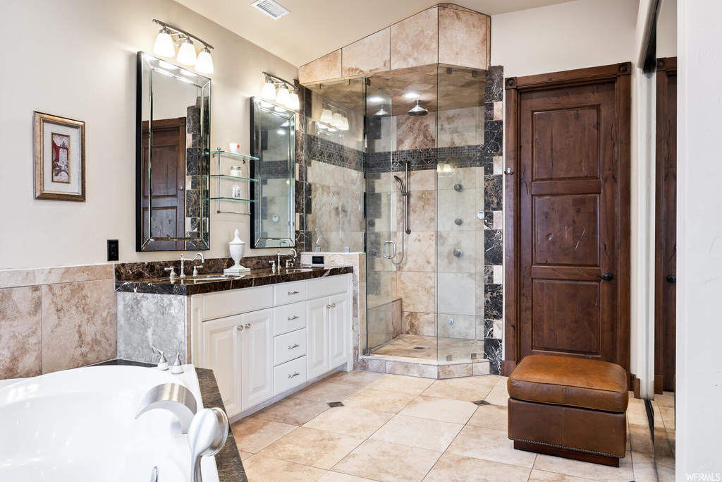 Bathroom with dual sinks, tile floors, separate shower and tub, and oversized vanity