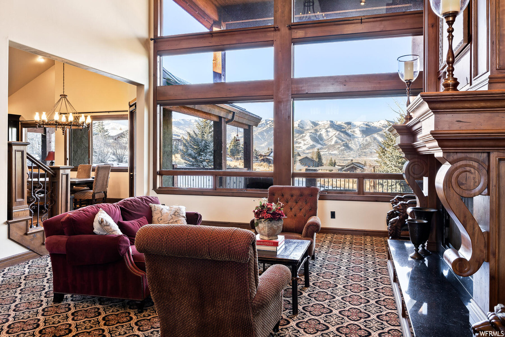 Living room with an inviting chandelier, a mountain view, and a high ceiling