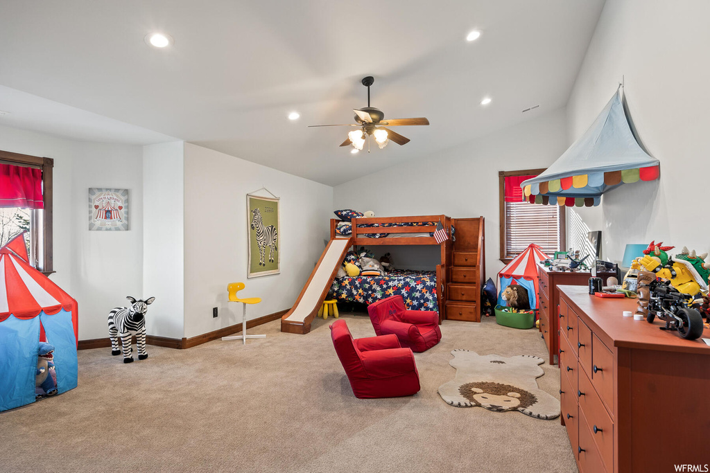 Bedroom with vaulted ceiling, light carpet, and ceiling fan