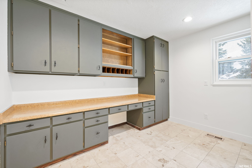 Interior space with gray cabinetry and light tile floors