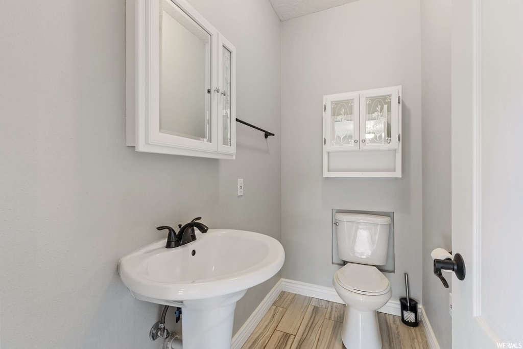 Bathroom with sink, toilet, and hardwood / wood-style floors
