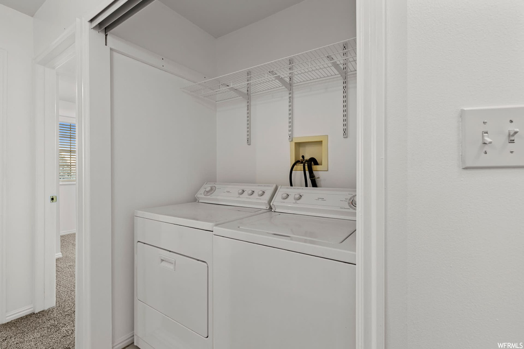 Laundry room with separate washer and dryer, hookup for a washing machine, and light carpet