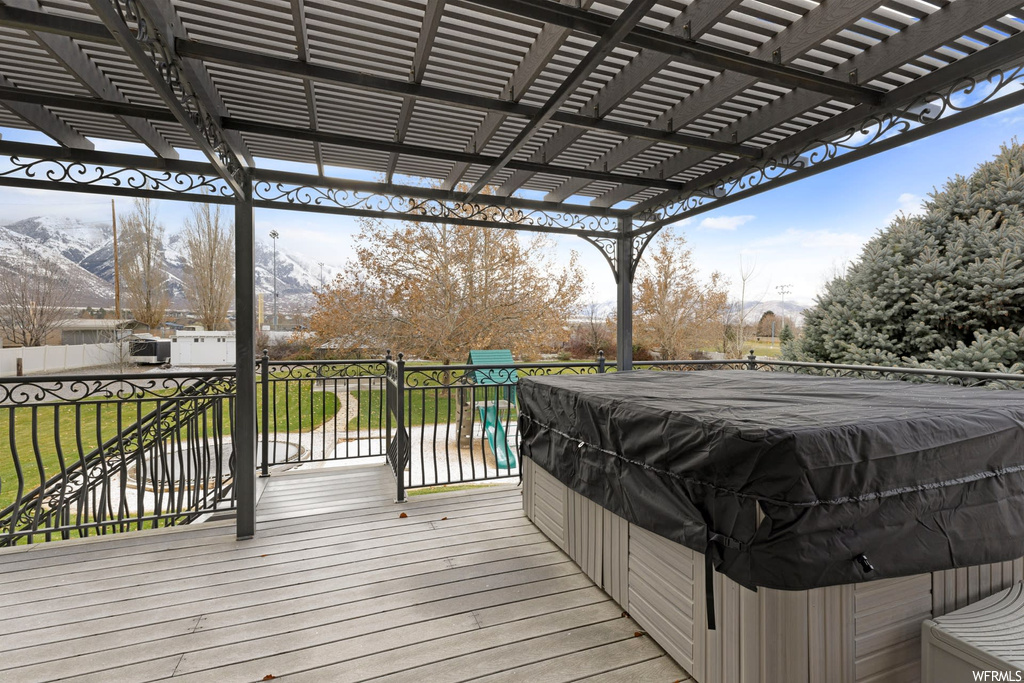 Wooden deck with a pergola and a mountain view