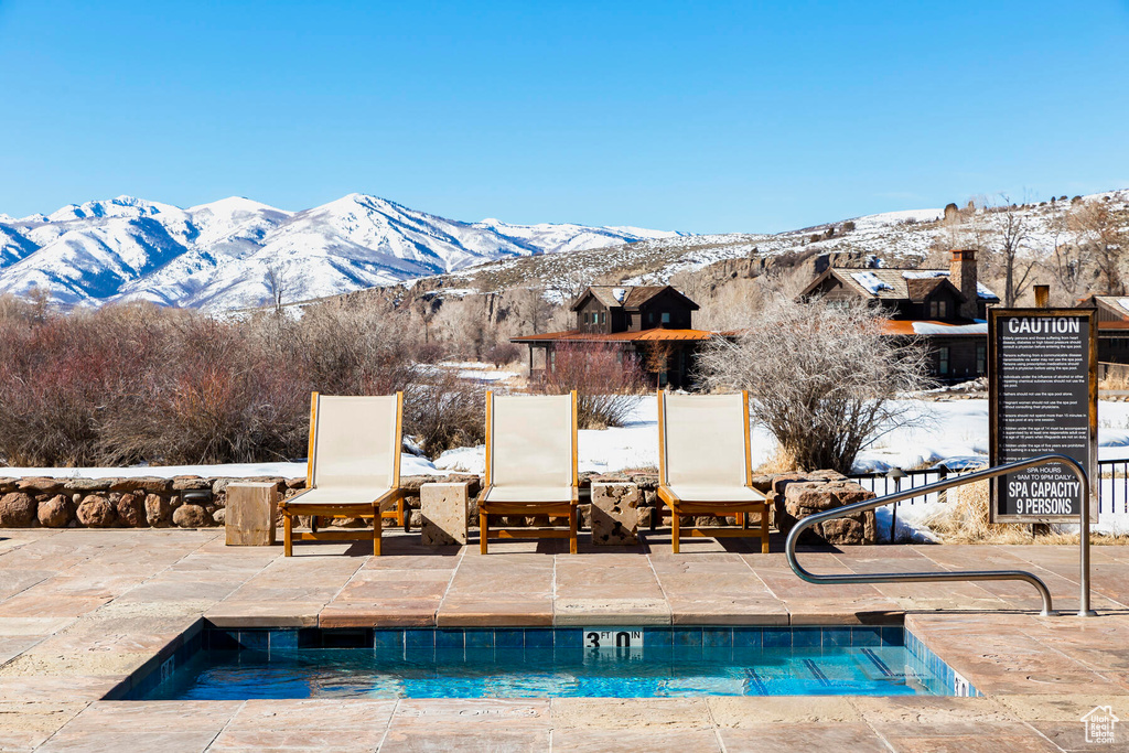 Snow covered pool featuring a mountain view