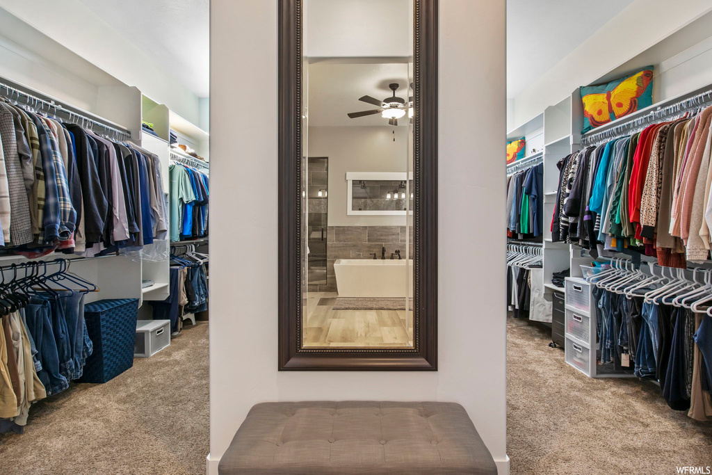 Spacious closet featuring light carpet and ceiling fan