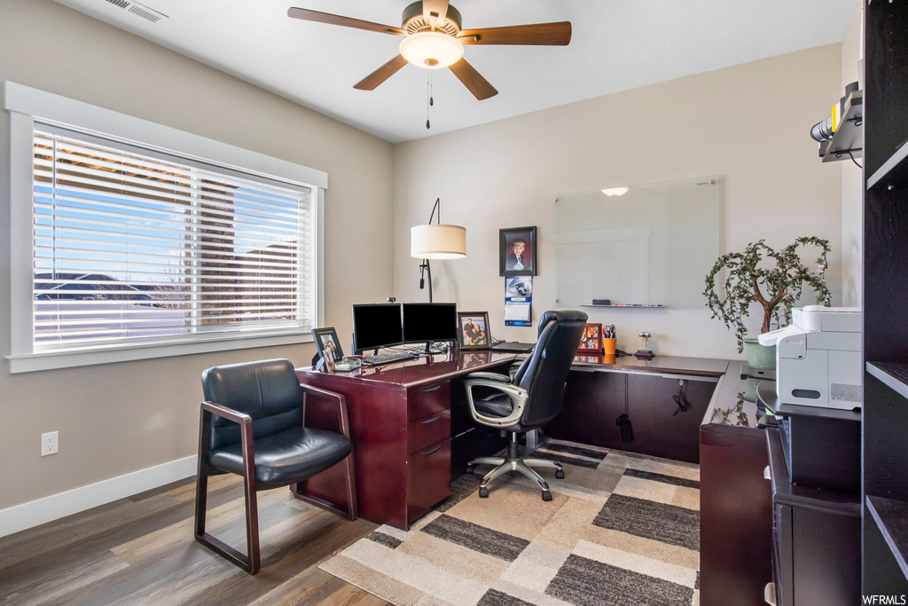 Home office featuring dark hardwood / wood-style floors and ceiling fan