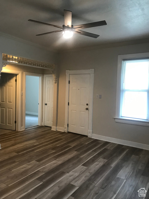 Unfurnished room with dark wood-type flooring, crown molding, and ceiling fan