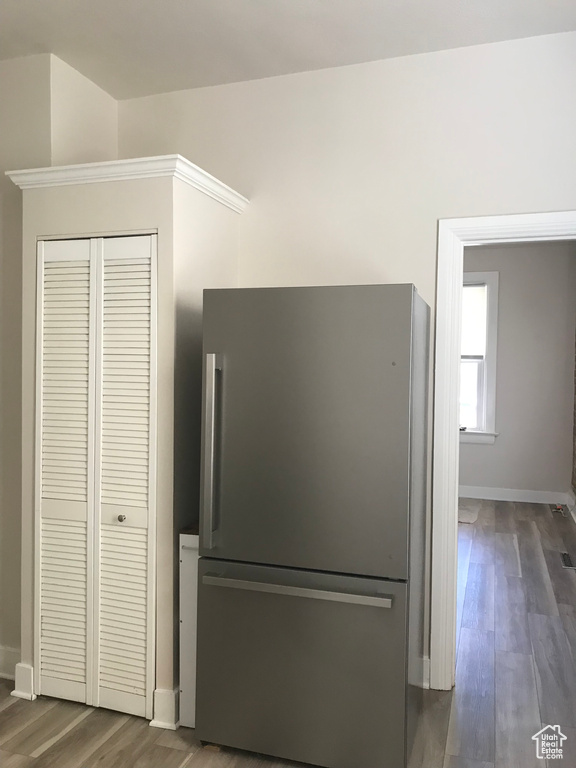 Room details with stainless steel refrigerator and dark wood-type flooring
