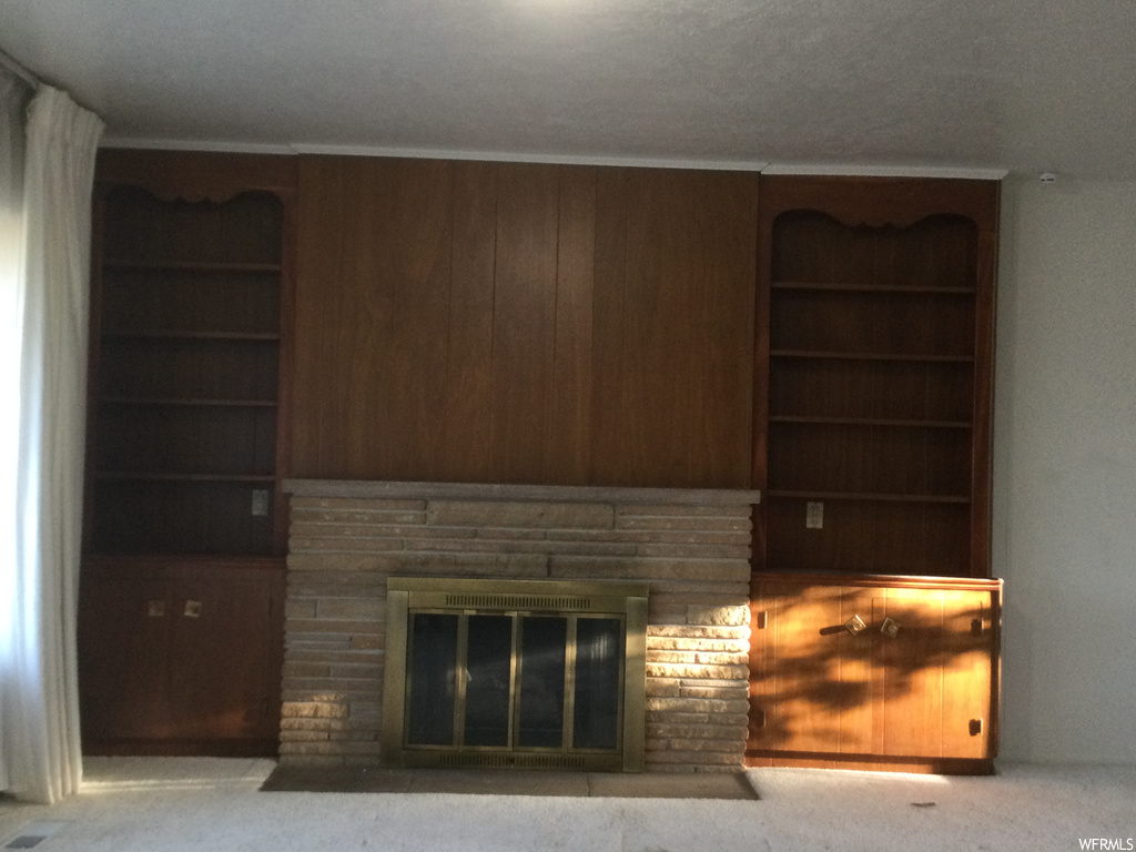 Details with light colored carpet, a fireplace, and built in shelves
