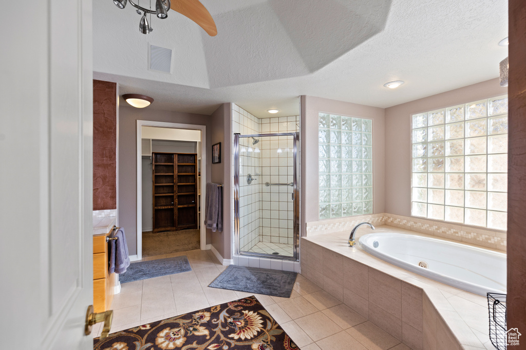 Bathroom with tile floors, separate shower and tub, a textured ceiling, and ceiling fan