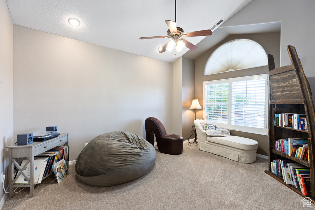 Sitting room with light colored carpet, ceiling fan, and lofted ceiling