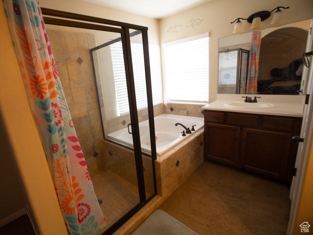 Bathroom featuring vanity and shower with separate bathtub