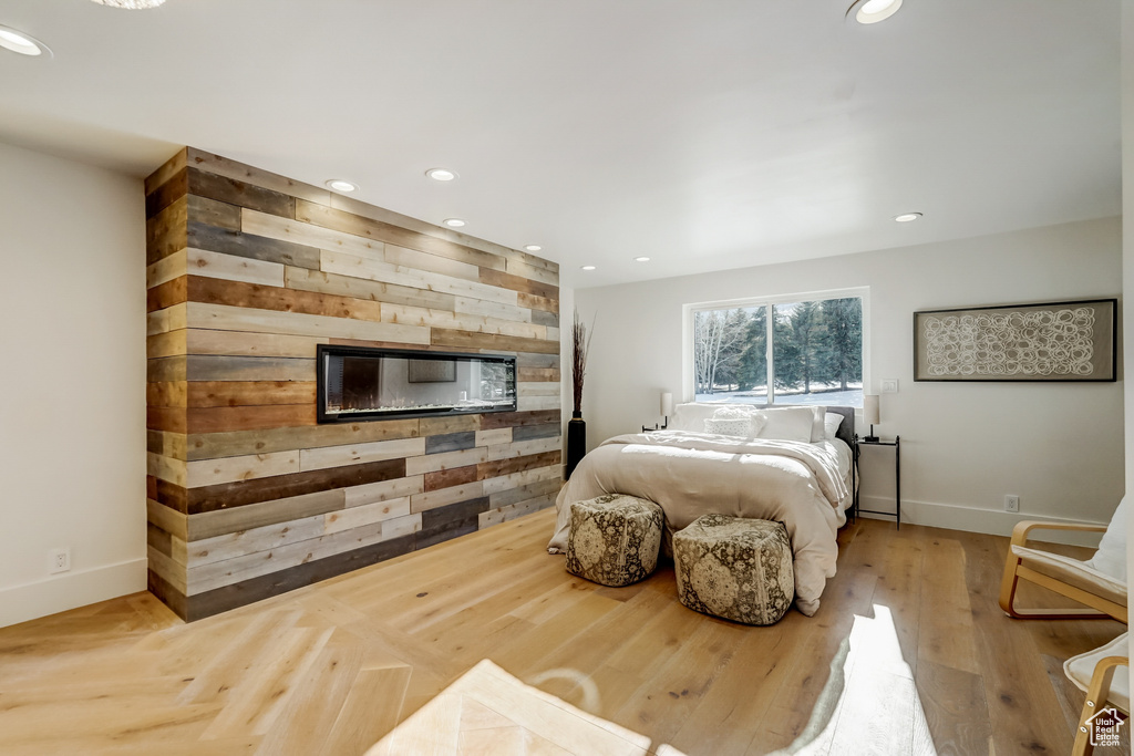 Bedroom with light hardwood / wood-style floors and wood walls