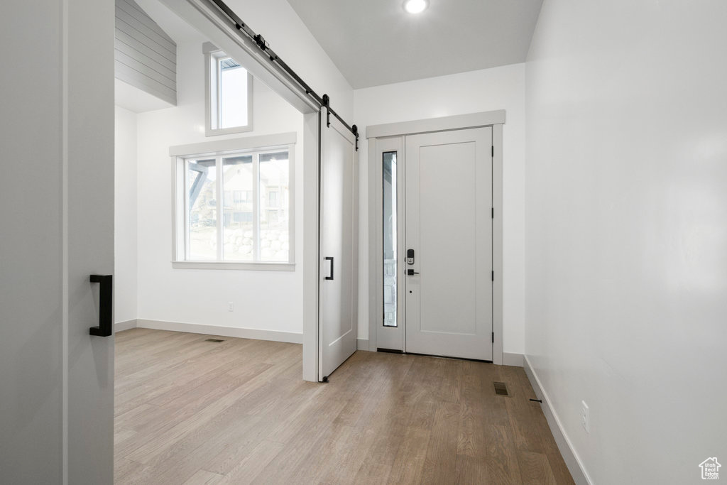 Entrance foyer featuring light hardwood / wood-style flooring and a barn door