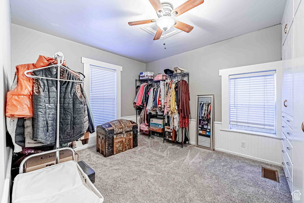 Spacious closet with light colored carpet and ceiling fan