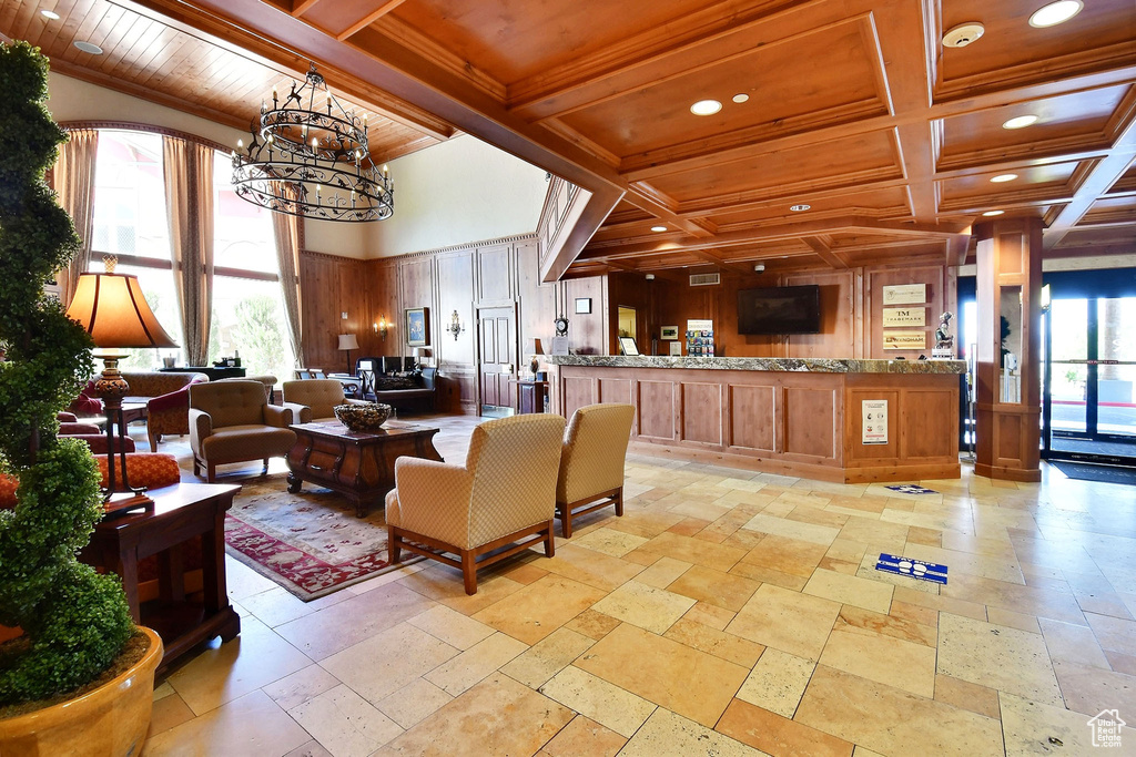 Tiled living room with beam ceiling, a chandelier, wooden ceiling, and coffered ceiling