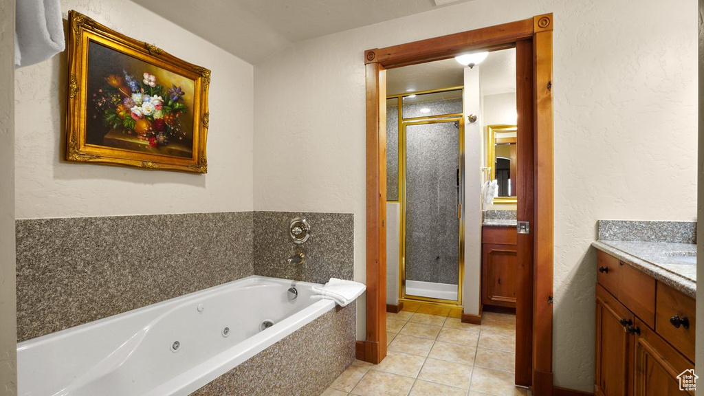 Bathroom with vanity, tile flooring, and shower with separate bathtub