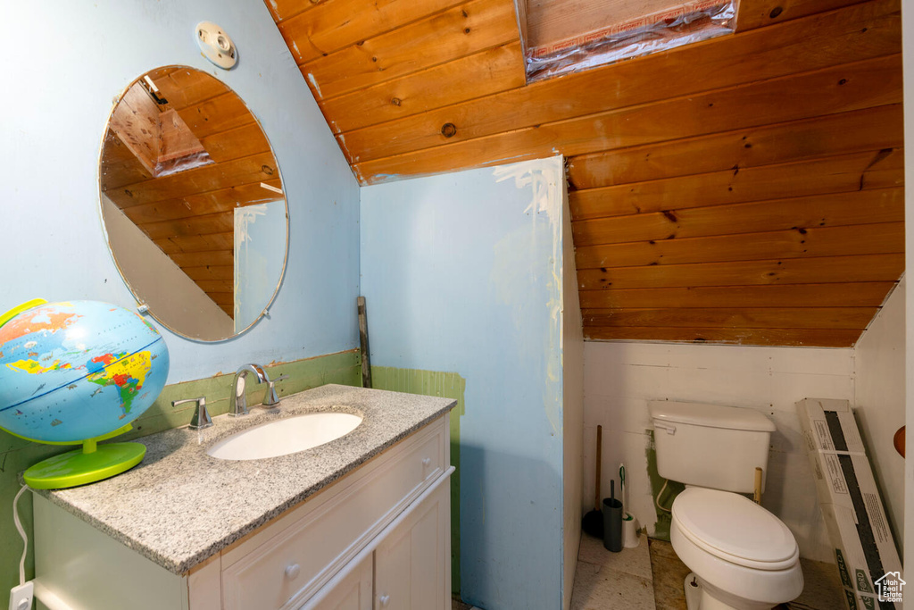 Bathroom with lofted ceiling, large vanity, toilet, and wood ceiling