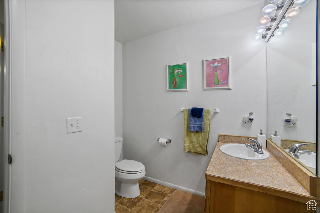 Bathroom with vanity, toilet, and tile flooring