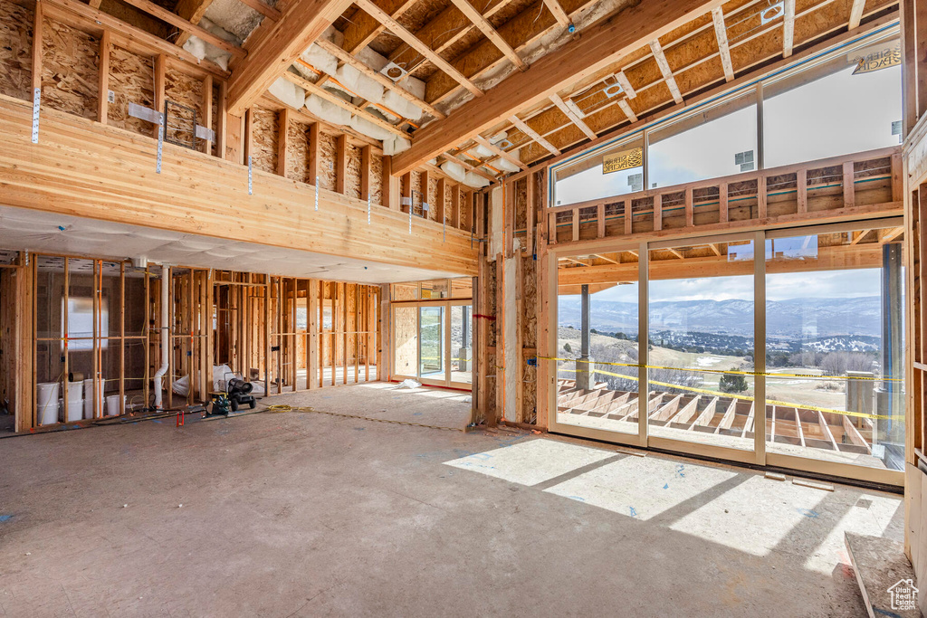 Misc room featuring concrete flooring, a high ceiling, and a mountain view