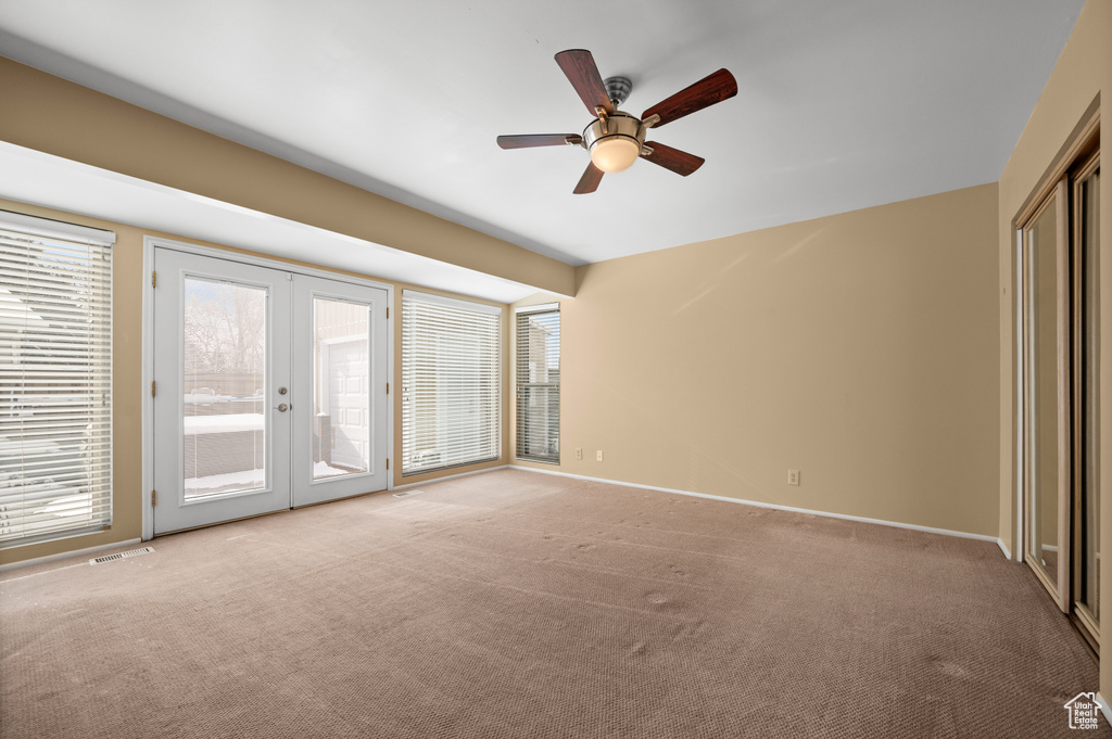 Unfurnished room featuring french doors, light colored carpet, and ceiling fan