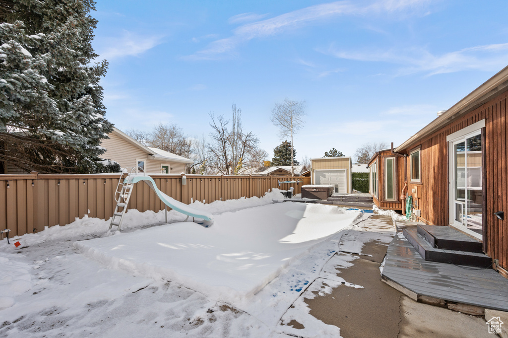 Yard layered in snow with a wooden deck