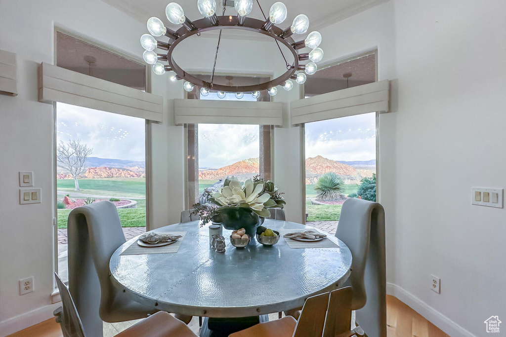 Dining room featuring an inviting chandelier, light wood-type flooring, and a mountain view