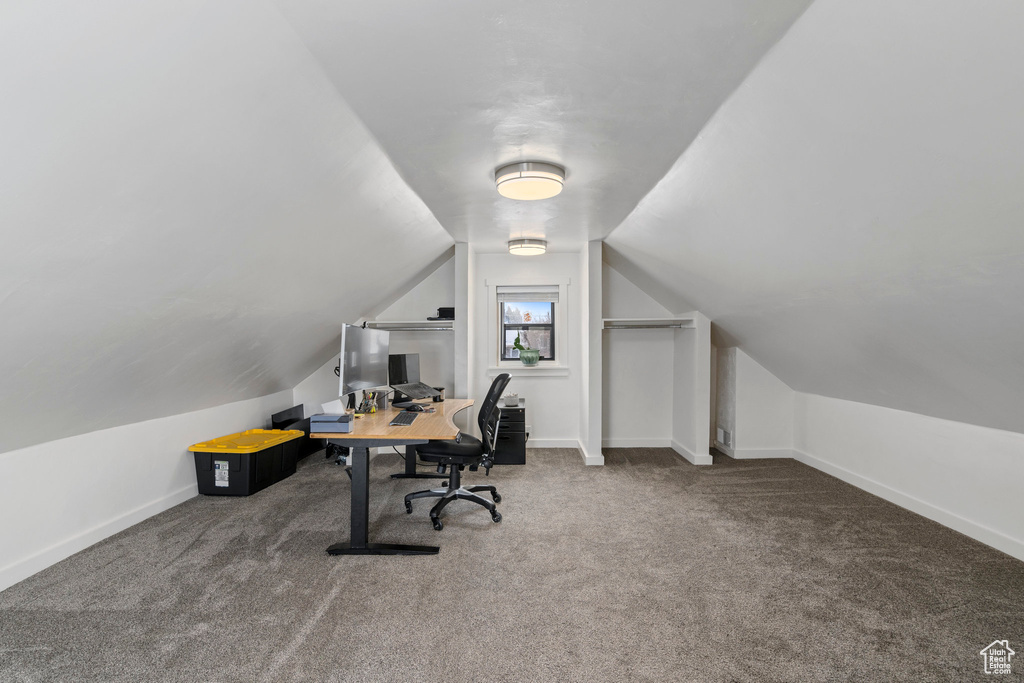 Home office featuring carpet floors and vaulted ceiling