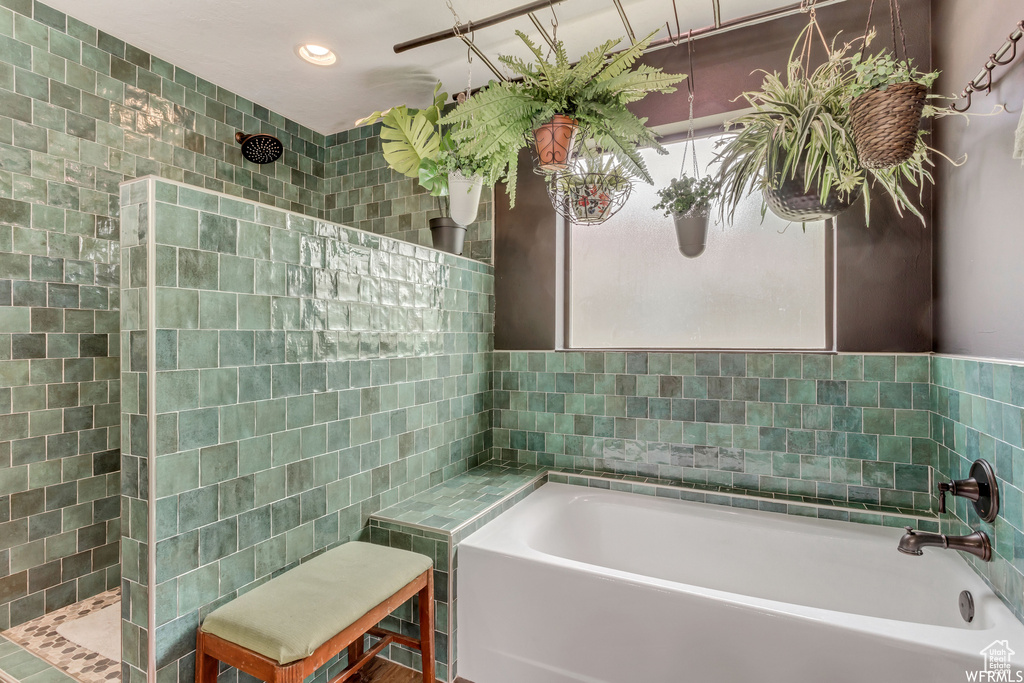 Bathroom featuring tile walls and a tub