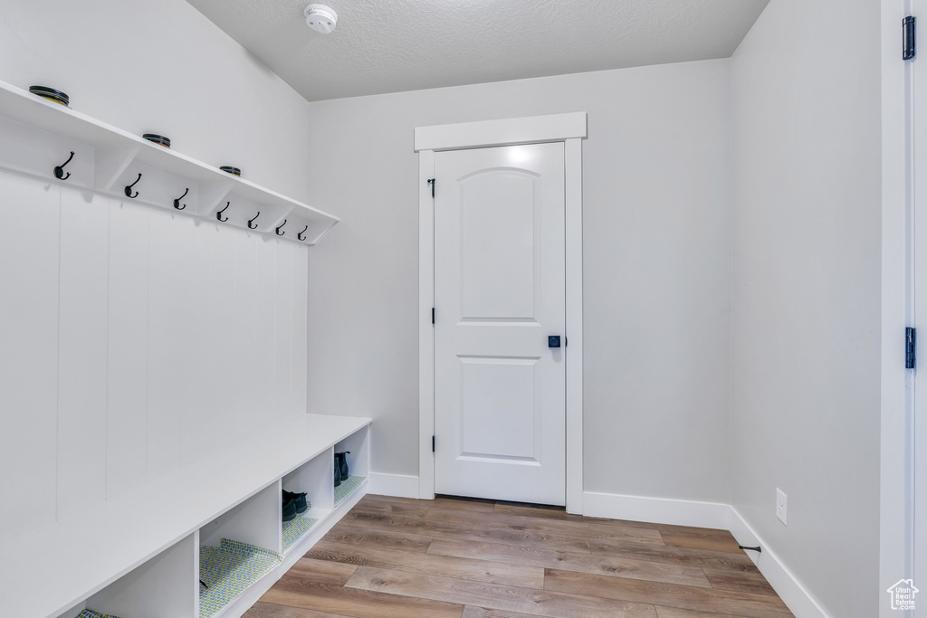 Mudroom with a textured ceiling and light hardwood / wood-style flooring