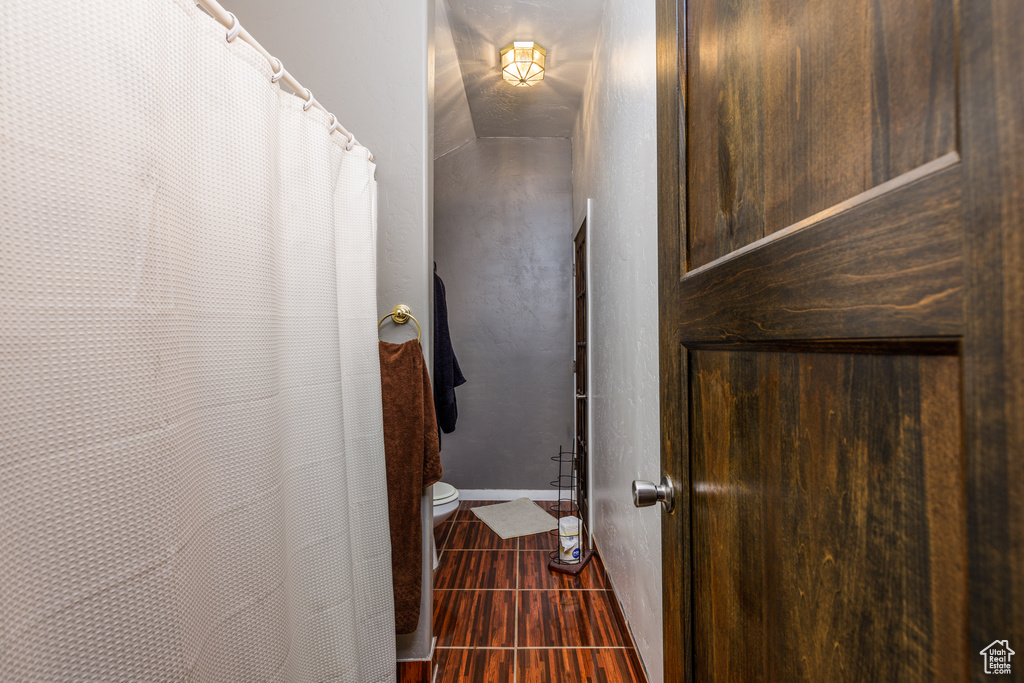 Room details with dark tile flooring and toilet