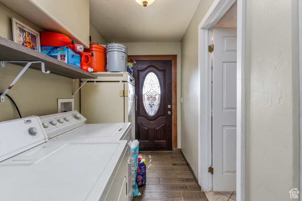 Laundry room featuring separate washer and dryer, a textured ceiling, dark hardwood / wood-style flooring, and washer hookup
