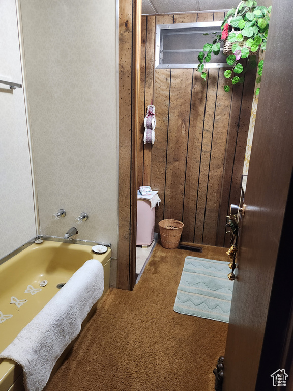 Bathroom with wooden walls and a bath