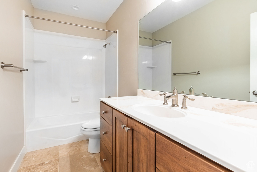 Full bathroom with toilet, vanity, washtub / shower combination, and tile flooring