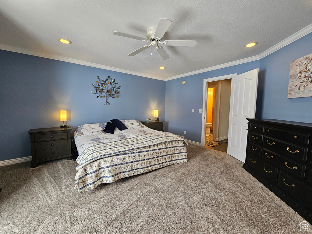 Carpeted bedroom featuring ornamental molding, ensuite bathroom, and ceiling fan
