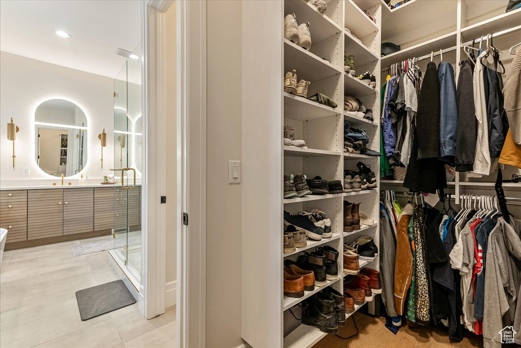 Spacious closet featuring sink and light tile flooring
