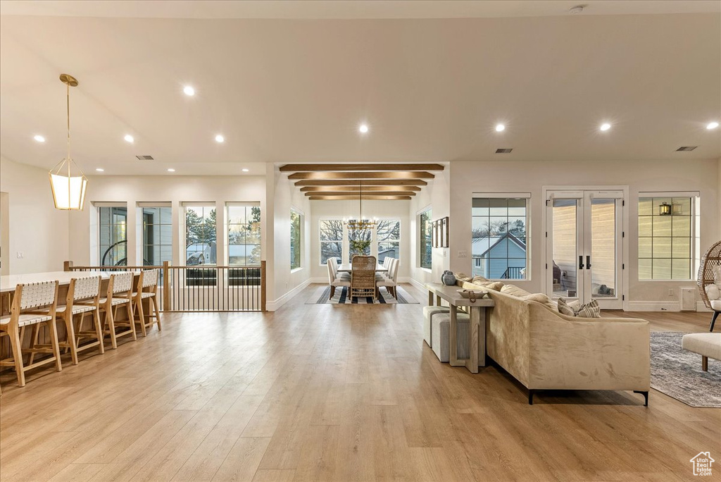 Living room with light hardwood / wood-style flooring and beamed ceiling