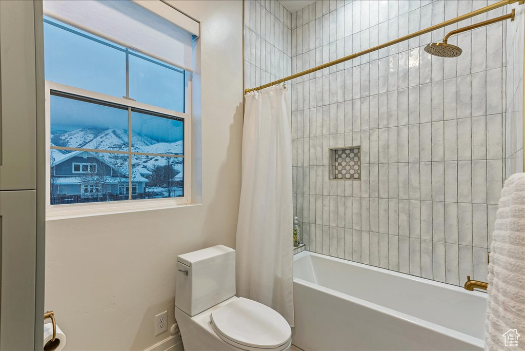 Bathroom with toilet, a healthy amount of sunlight, and shower / bathtub combination with curtain