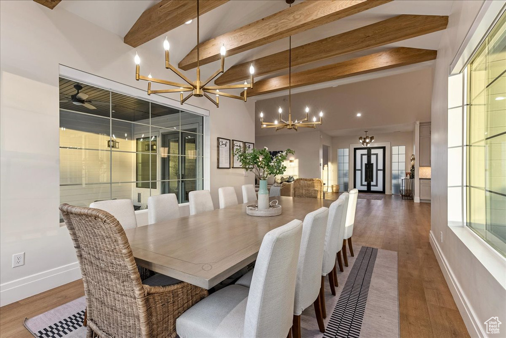 Dining area featuring an inviting chandelier, french doors, beam ceiling, high vaulted ceiling, and dark hardwood / wood-style floors