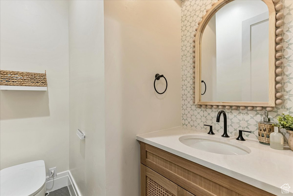 Bathroom featuring tasteful backsplash, toilet, and oversized vanity