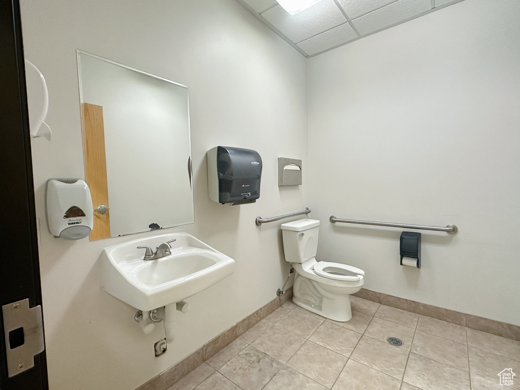 Bathroom with tile floors, sink, toilet, and a paneled ceiling