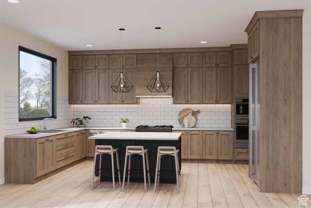 Kitchen with decorative light fixtures, a kitchen bar, light hardwood / wood-style floors, a kitchen island, and tasteful backsplash
