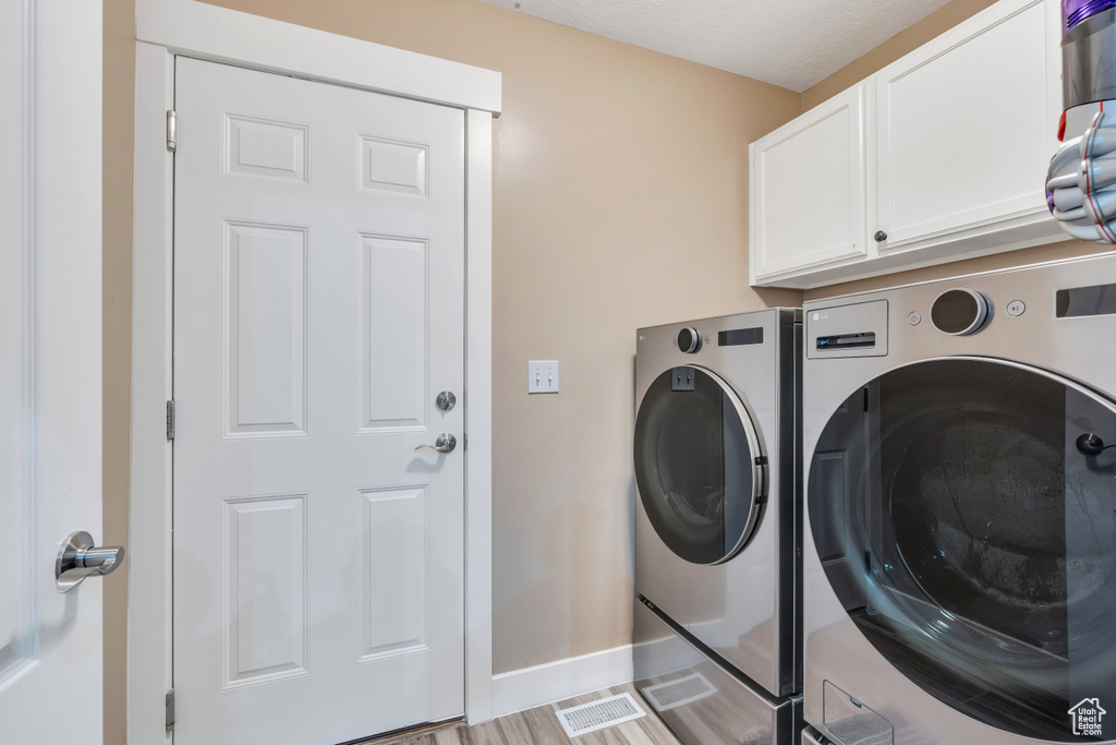 Laundry room with cabinets and washer and dryer