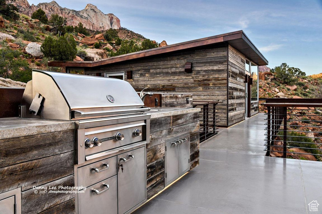 View of patio with grilling area, an outdoor kitchen, and a mountain view
