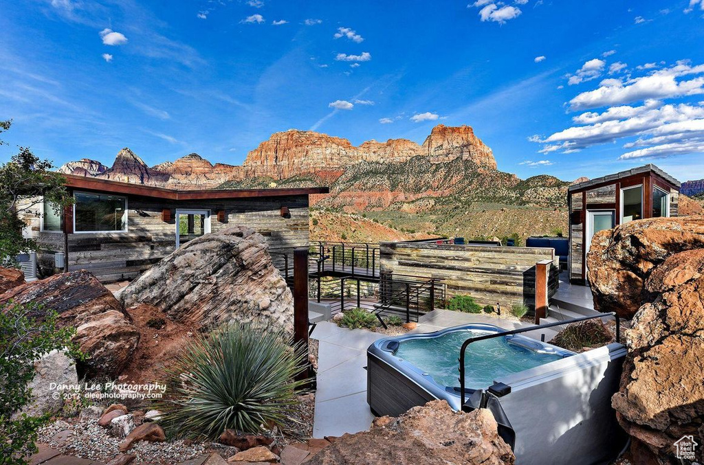 Exterior space with a mountain view, a hot tub, and central AC