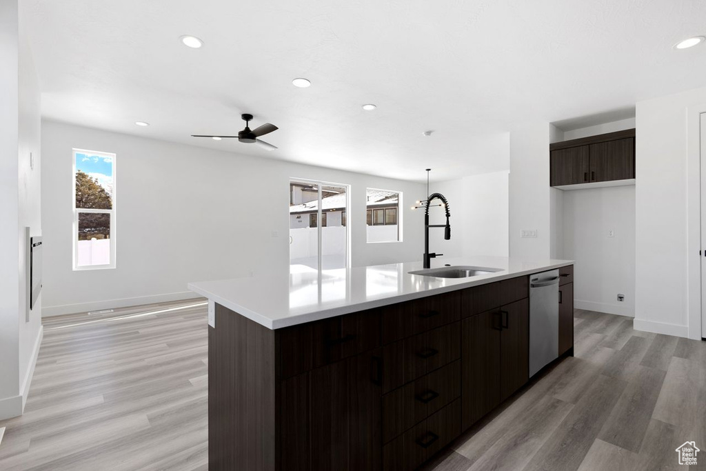 Kitchen with sink, a kitchen island with sink, light hardwood / wood-style flooring, and ceiling fan