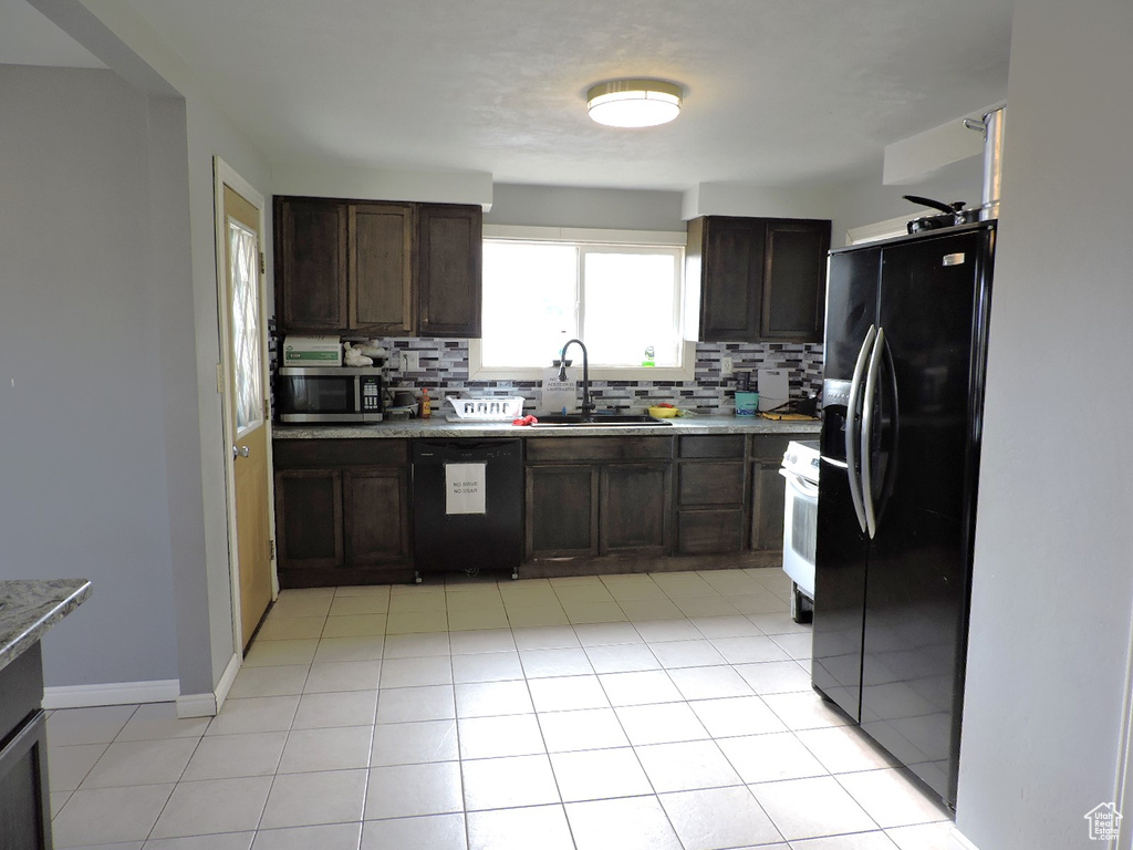 Kitchen with black appliances, tasteful backsplash, light tile flooring, and dark brown cabinets