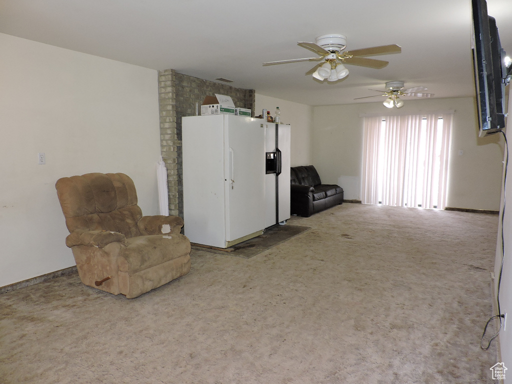 Unfurnished room with brick wall, light carpet, and ceiling fan